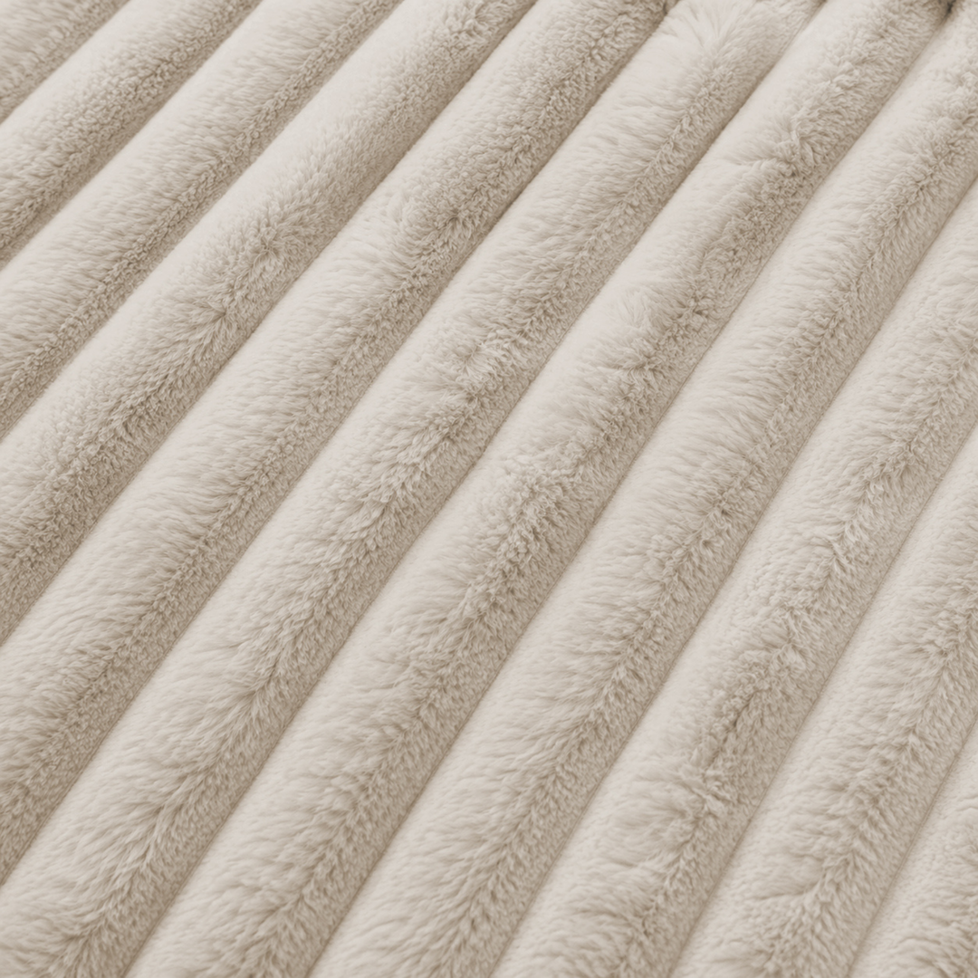 Détail du tissu en fourrure côtelée beige, reliefs verticaux et finition du velours.