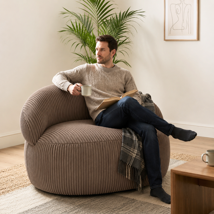 Personne assise sur un pouf XXL en velours côtelé, dans un salon